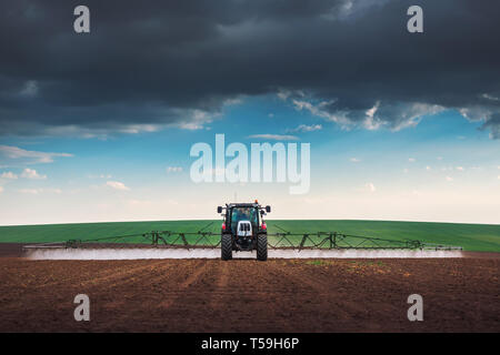 Tracteur agricole labourer et pulvériser sur terrain Banque D'Images