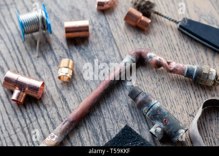 Close-up, soudure, plomberie outils professionnel de la construction, pièces de tubes en cuivre sur un fond de bois. Concept de réparation professionnelle d'eau s Banque D'Images