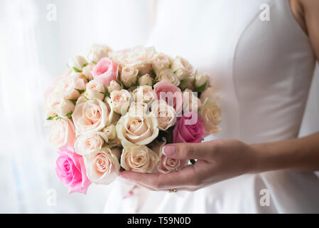 Beau mariage bouquet de roses beige délicat dans les mains de la mariée Banque D'Images