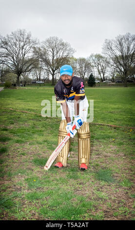 Un batteur de cricket américaine dans la vingtaine qui pose pour une photo lors d'un tournoi en Baisley Pond Park en Jamaïque, Queens, New York. Banque D'Images