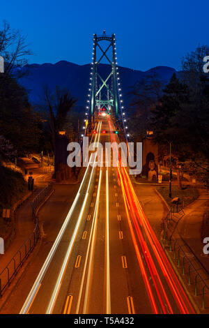 Photo d'une longue exposition à orientation verticale du pont Lions Gate avec une silhouette de Grouse Mountain en arrière-plan à Vancouver, British Columb Banque D'Images