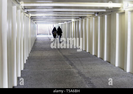 Un couple en train de marcher dans le passage souterrain. Vue en perspective. Concept de l'espace urbain. Banque D'Images