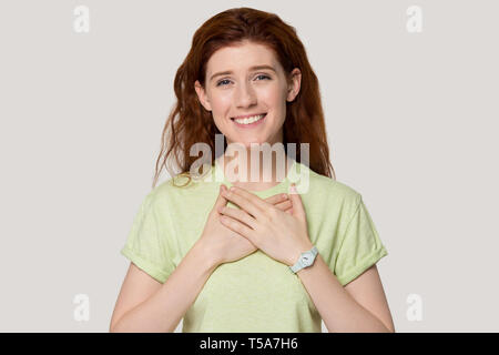 Reconnaissant fille rousse avec les mains sur la poitrine se sentent reconnaissants Banque D'Images