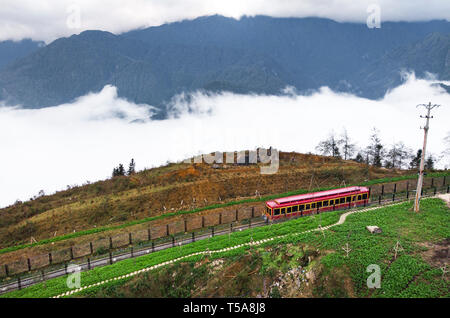 SAPA, Vietnam : téléphérique rouge en haut de la montagne de Fansipan, la plus haute montagne de l'Indochine. Train Voiture rouge dans le brouillard dans les montagnes au-dessus Banque D'Images