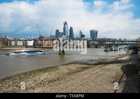 Un bateau qui passe sous le Millenium Bridge sur la Tamise à Londres. Banque D'Images