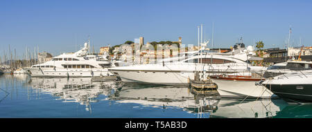 CANNES, FRANCE - AVRIL 2019 - Vue panoramique de superyachts ancrés dans le port de Cannes. Dans l'arrière-plan est le château et l'église catholique Banque D'Images