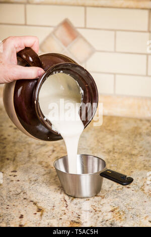 Woman measuring levain pour ajouter à une recette de pain au levain. (MR) Banque D'Images