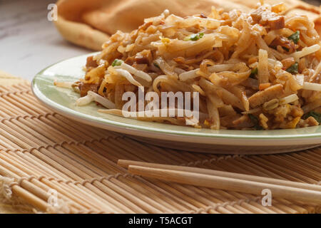 Cuisine authentique pad thaï avec du porc riz nouilles de tofu fumé fèves germées arachides et garnir de chaux Banque D'Images