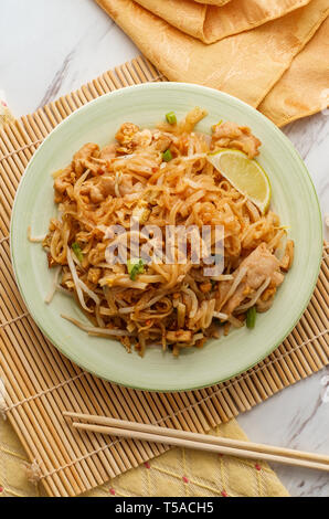 Cuisine authentique pad thaï avec du porc riz nouilles de tofu fumé fèves germées arachides et garnir de chaux Banque D'Images