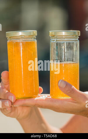 Woman holding pots de miel qui ont été tendues, fraîchement extrait et mis en bouteille. (MR) Banque D'Images