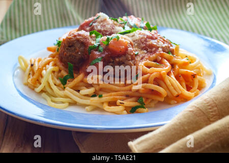 Spaghetti et boulettes de viande italienne faits maison garni de tranches de fromage parmesan et les feuilles de persil Banque D'Images