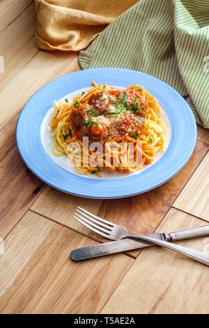 Spaghetti et boulettes de viande italienne faits maison garni de tranches de fromage parmesan et les feuilles de persil Banque D'Images