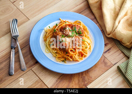 Spaghetti et boulettes de viande italienne faits maison garni de tranches de fromage parmesan et les feuilles de persil Banque D'Images