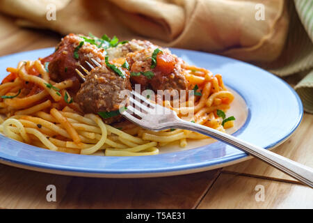 Spaghetti et boulettes de viande italienne faits maison garni de tranches de fromage parmesan et les feuilles de persil Banque D'Images