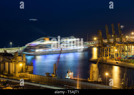 La nuit du Port de Barcelone en Catalogne, Espagne, des grues en légèreté d'un navire de croisière sur la Mer Méditerranée Banque D'Images