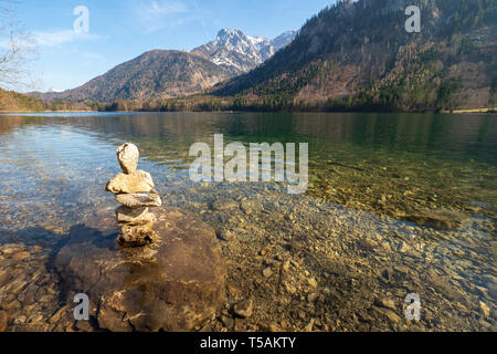 Tas de pierres formant une sculpture (un soi-disant "toamandl') debout dans les eaux peu profondes de l'eau claire comme du cristal du Langbathsee Vorderer, OÖ, Autriche Banque D'Images