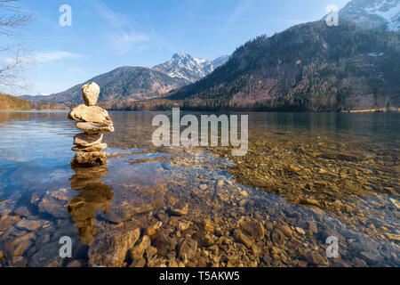 Tas de pierres formant une sculpture (un soi-disant "toamandl') debout dans les eaux peu profondes de l'eau claire comme du cristal du Langbathsee Vorderer, OÖ, Autriche Banque D'Images