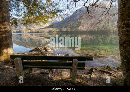 Banc en bois vide sur la côte des Vorderer Langbathsee près d'Ebensee, OÖ, l'Autriche, avec le grand paysage reflétant sur l'eau cristalline Banque D'Images