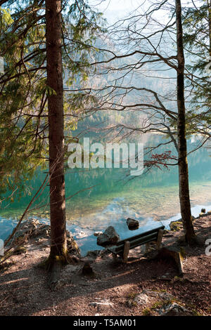 Banc en bois vide sur la côte des Vorderer Langbathsee près d'Ebensee, OÖ, l'Autriche, avec le grand paysage reflétant sur l'eau cristalline Banque D'Images