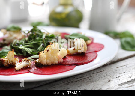 Vegetarian carpaccio de betteraves rôties avec le chou-fleur et salade verte. Banque D'Images