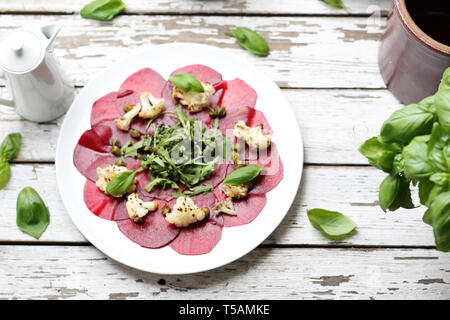 Vegetarian carpaccio de betteraves rôties avec le chou-fleur et salade verte. Banque D'Images