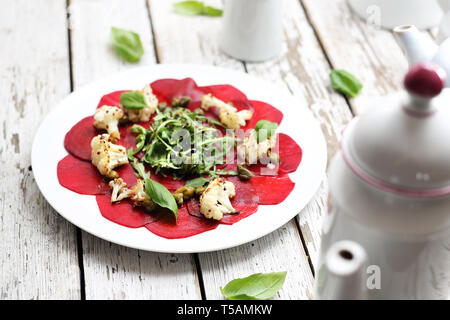 Vegetarian carpaccio de betteraves rôties avec le chou-fleur et salade verte. Banque D'Images