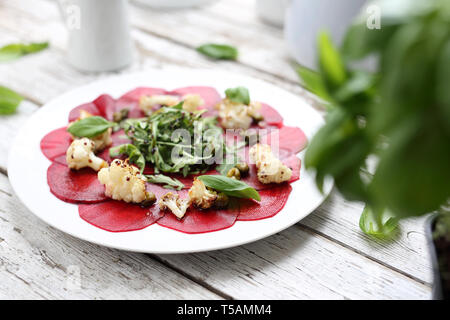 Vegetarian carpaccio de betteraves rôties avec le chou-fleur et salade verte. Banque D'Images