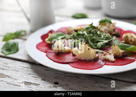 Vegetarian carpaccio de betteraves rôties avec le chou-fleur et salade verte. Banque D'Images