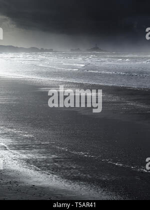 La baie de Saint-ouen à Jersey, Channel Islands, la plus longue plage de l'île, montrant la Corbiere Lighthouse au loin. Banque D'Images