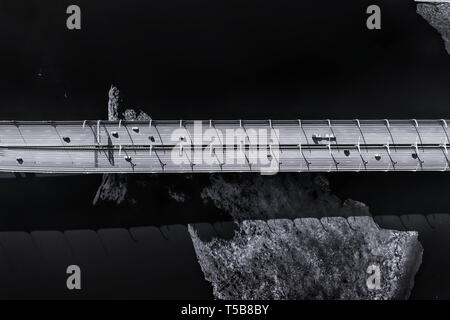 La circulation sur route surélevée sur la mer froide avec de la glace Vue aérienne. Photo noir et blanc sombre Banque D'Images