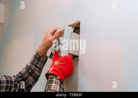 Électricien au travail mur coupe pour le câblage électrique de différents câbles à la paroi Banque D'Images