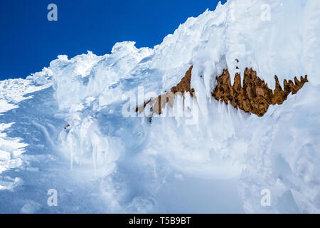 Près du sommet du Mont Shasta, le givre blanc enrobe les falaises de roche rouge volcanique rouge les banques sur le volcan dormant en Californie. Banque D'Images