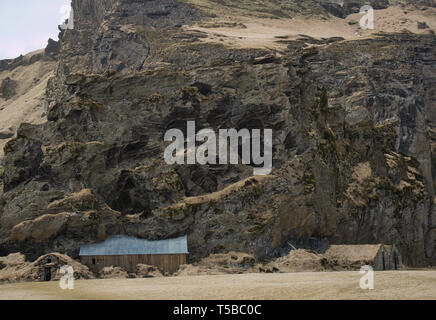 Seul Gros rock avec les anciennes granges de la ferme Drangshlid en Islande Banque D'Images