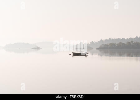 Bateau de pêche sur le Loch Lomond près de Chiddingfold dans la brume du matin, Scotland, UK Banque D'Images