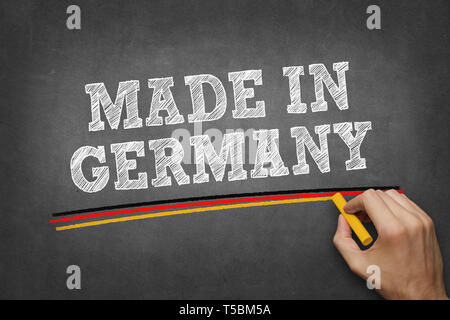 La main Fabriqué en Allemagne on chalkboard - soulignant avec couleurs de drapeau allemand Banque D'Images