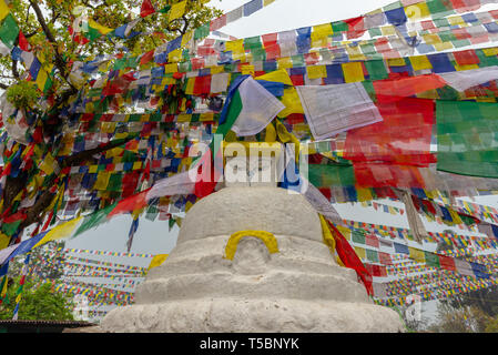 Un stuppa bouddhiste (monument religieux) et de nombreux drapeaux de prière sous un ciel couvert matin de printemps au monkey temple à Katmandou, Népal Banque D'Images