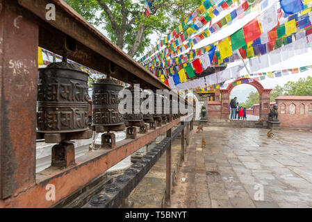 Katmandou, Népal - 30 mars 2019 : une famille et roues de prière près du monastère bouddhiste au temple des singes, Swayambhunath, Népal Banque D'Images