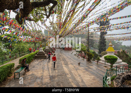 Katmandou, Népal - Mars 30, 2019 : peu de visiteurs et les lignes de drapeaux de prières formant des lignes convergentes avec quelques rayons de soleil, Swayambhunath, Népal Banque D'Images