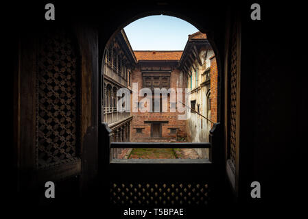 Vue depuis une chambre obscure sur l'un de la cour intérieure de la fenêtre 55 Palace situé dans le centre historique de Bhaktapur, Népal Banque D'Images