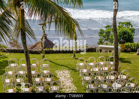 Arche de mariage pour une cérémonie décorée de fleurs fraîches, chaises et parasols pour les clients parmi les palmiers près de l'océan. Mariage Tropical. Banque D'Images