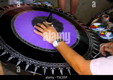 Un parapluie de papier peinture travailleur à Chiang Mai, Thaïlande Banque D'Images