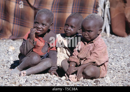 La Namibie. Village de la tribu Himba. Les enfants assis à l'extérieur. Banque D'Images