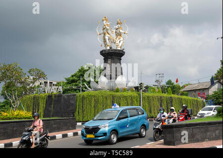 Un célèbre taxi Bluebird près d'une des nombreuses statues Hindoues qui ornent les ronds-points à Jimbaran, Bali, Indonésie Banque D'Images