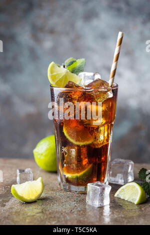 Cuba Libre frais avec rhum brun, cola, Menthe et citron sur fond noir en gris Banque D'Images