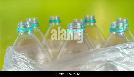D'étranglement d'un pack de 8 vide et des bouteilles d'eau en plastique recyclable, sans plafond, Sea Green Seal, à l'intérieur d'un sac en plastique, de couleur jaune vif sur un Banque D'Images