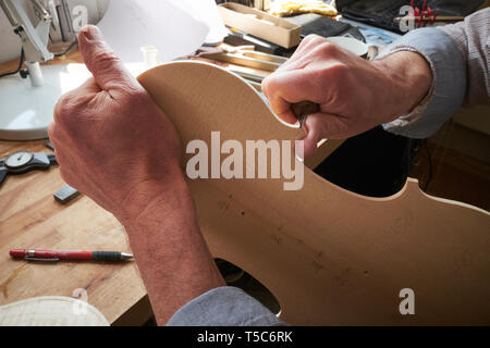 Luthier à travailler à Londres, au Royaume-Uni, la sculpture l'arrière d'un violon Banque D'Images