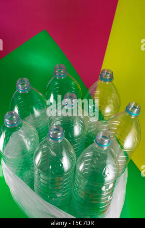 Un pack de 8 vide et des bouteilles d'eau en plastique recyclable, sans plafond, blue seal, dans un sac en plastique, sur une dynamique de couleur géométriques sea green, vin Banque D'Images