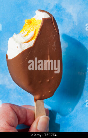 Manger des oeufs Cadbury crème glace à fond bleu - Notion de manger de la crème glacée aux beaux jours avec ciel bleu Banque D'Images