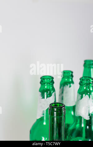 Image de l'étranglement de la bière et du vin vide les bouteilles en verre vert sur fond blanc. Réutiliser, Recycler, acoholism et party concept. Banque D'Images