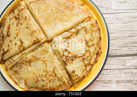 La cuisine russe traditionnelle, de délicieuses crêpes sur une assiette, empilées pile. Le carnaval et en voyant l'hiver russe, vue de dessus. Banque D'Images